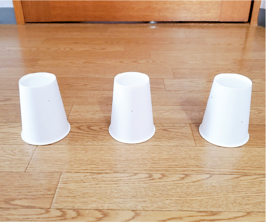 小さな穴をあけた紙コップを何個か用意し、ひっくり返して床に置きます